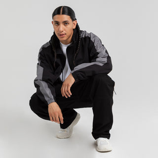 Men's black windbreaker jacket, hooded full-zip with gray contrast sleeve panels.