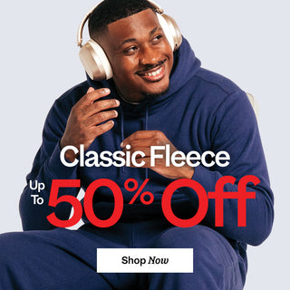 Man wearing a blue hoodie and headphones with promotional text for classic fleece on a light gray background