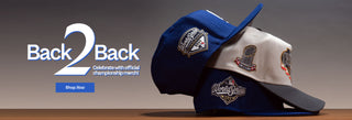 Two baseball caps with logos on a wooden surface, featuring 'Back2Back' branding.