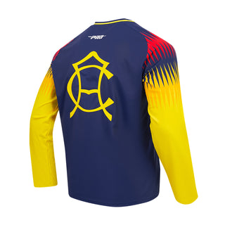 Angled back view of Club America tee with large yellow emblem and patterned long sleeves