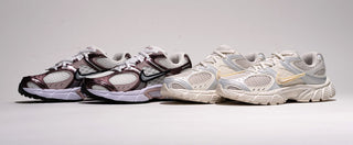 Two pairs of Nike running shoes in black, silver, and white on a light gray background.